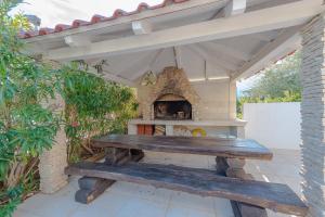 a wooden bench sitting on a patio with a fireplace at After All in Mandre