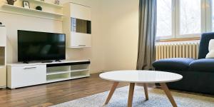 sala de estar con TV, sofá y mesa en FilinHome Stefanovica Suite 2, en Novi Sad