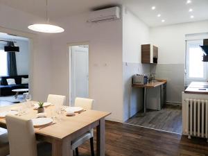 - une salle à manger et une cuisine avec une table et des chaises dans l'établissement FilinHome Stefanovica Suite 2, à Novi Sad