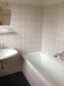 y baño con bañera blanca y lavamanos. en Haus Elsa, en Ramsau am Dachstein