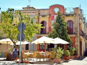 a restaurant with tables and umbrellas in front of a building at Villa Madau in Pula