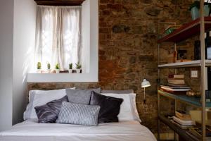 a bed in a room with a brick wall at Small loft at Casa Neuman, Casco Antiguo in Panama City