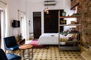 a bedroom with a bed and a table and a chair at Small loft at Casa Neuman, Casco Antiguo in Panama City
