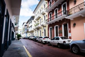 a row of cars parked on a street with buildings at Small loft at Casa Neuman, Casco Antiguo in Panama City