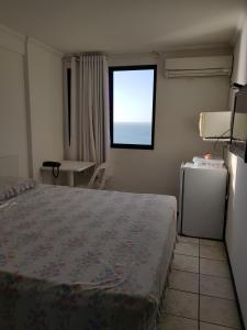 Un dormitorio con una cama grande y una ventana en Apart Porto Jangada Suíte Vista Mar, en Fortaleza