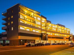 a large building with cars parked in front of it at Modern & Cozy Unit Just Steps from Terrigal Beach in Terrigal