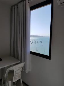 una ventana con vistas al agua y a los barcos en Apart Porto Jangada Suíte Vista Mar, en Fortaleza