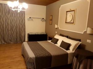 a bedroom with a bed and a chandelier at Suite Umberto I in Assisi