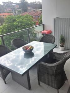 a table with a bowl of fruit on a balcony at Modern & Cozy Unit Just Steps from Terrigal Beach in Terrigal