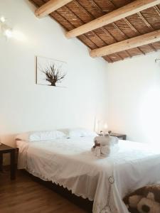 Un dormitorio con una cama blanca con un osito de peluche. en Dabbanna, en Chiaramonte Gulfi