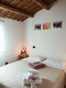 um quarto com uma cama branca e toalhas em Dabbanna em Chiaramonte Gulfi