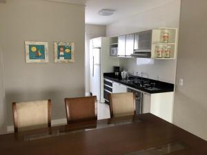 cocina con mesa y sillas en una habitación en Costa Azul - EXCELENTE LOCALIZAÇÃO, en Bombinhas