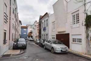 アヴェイロにあるSalineiras Center Apartmentの二台の車が建物のある街路に停められた