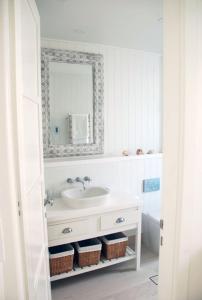 a white bathroom with a sink and a mirror at Bluebell in Forster +7 photos