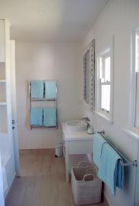 a white bathroom with a sink and a mirror at Bluebell in Forster