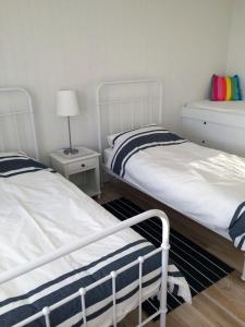 a bedroom with two beds and a lamp in it at Bluebell in Forster +7 photos