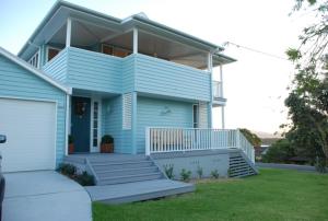 a blue house with a porch and a garage at Bluebell in Forster