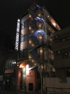 東京にあるビジネスホテルクレセントの夜間の看板が貼られた高層ビル