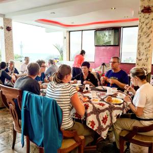 eine Gruppe von Menschen, die an einem Tisch in einem Restaurant sitzen in der Unterkunft Galápagos Eco Friendly in Puerto Baquerizo Moreno