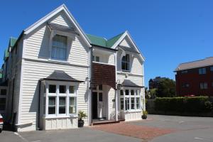 Casa blanca con techo verde en The Grange B&B, en Christchurch