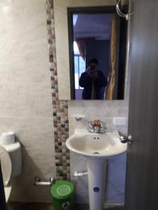 mężczyzna robiący zdjęcie łazienki z umywalką w obiekcie Hotel Casa Blanca Mirador w mieście Güicán