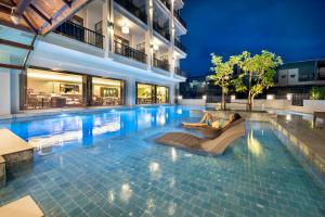 a person laying on a chair in a swimming pool at Monkham Village Hat Yai in Hat Yai