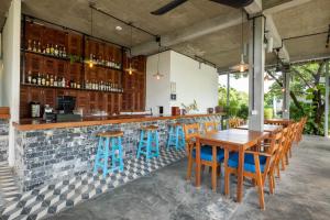 um bar ao ar livre com mesas de madeira e bancos azuis em Pippali Boutique Hotel em Kampot