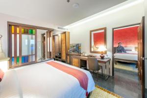 a hotel room with a bed and a desk and a bedroom at Monkham Village Hat Yai in Hat Yai