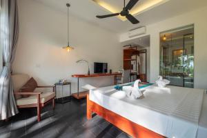 Pippali Boutique Hotel في كامبوت: غرفة نوم مع سرير وغرفة معيشة