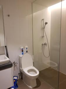 a bathroom with a toilet and a glass shower at The Establishment Bangsar in Kuala Lumpur
