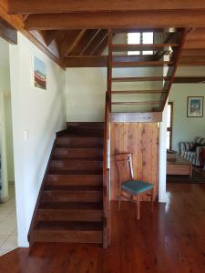 a staircase in a house with a chair and a stair case at Seafarer Cottage in South Mission Beach