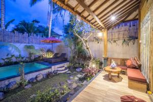 un patio con piscina, banco y mesa en The Forest Batu Kurung Ubud, en Ubud