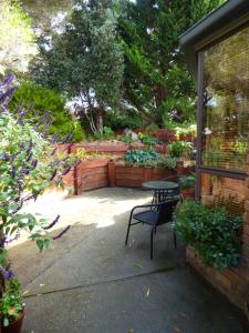 a patio with a table and a chair in a garden at A Suite Spot in the Hills in Mount Barker