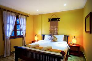a bedroom with a bed with yellow walls at Villa D Riverside Boutique Hotel in Siem Reap