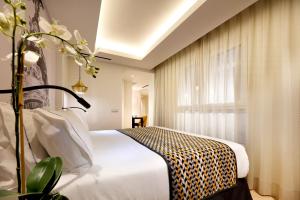 a bed room with a white bedspread and a white dresser at Eurostars Madrid Gran Vía in Madrid