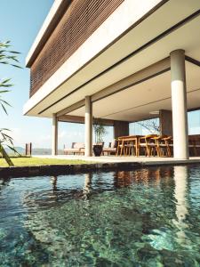 - une vue extérieure sur une maison avec une piscine dans l'établissement Villa Strata, à Kuta Lombok