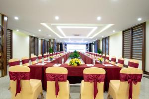 Muong Thanh Sapa Hotel في سابا: قاعة اجتماعات طويلة مع طاولة وكراسي طويلة