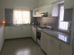 a kitchen with white cabinets and a stove top oven at Aura Norte Home in Salta