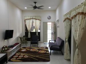 uma sala de estar com um sofá e cadeiras e uma sala de estar em Rumah Melaka em Malaca