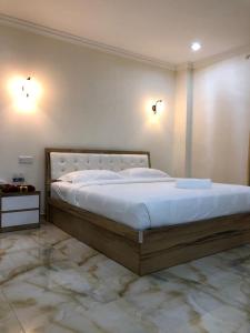 een slaapkamer met een groot bed met witte lakens bij CLASSIC KINABALU VILLA in Kota Kinabalu