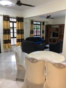 een woonkamer met een tafel en stoelen bij CLASSIC KINABALU VILLA in Kota Kinabalu