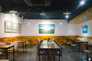 a restaurant with tables and chairs and a painting on the wall at Nampo HILL Guesthouse in Busan
