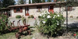 a stone house with a garden with flowers in front of it at Agriturismo Collomici in Celle sul Rigo