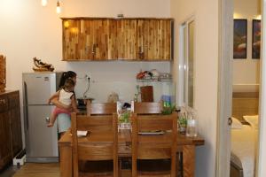 a little girl sitting on a chair in a kitchen at Coast Homestay in Tuy Hoa