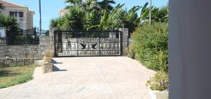 a driveway with a black wrought iron gate at AnnaMaria House in Laganas