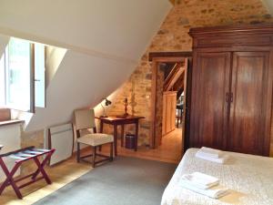 a bedroom with a bed and a table and a chair at Maison Milou in Beynac-et-Cazenac