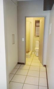 a hallway with a bathroom with a toilet in it at Samtip Sunset in Johannesburg