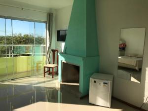 een woonkamer met een open haard en een televisie bij Apart Hotel Alegrete in Alegrete