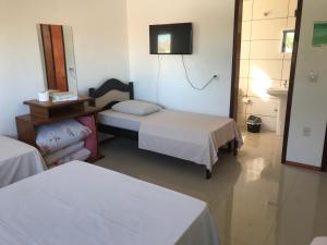 a hotel room with two beds and a television at Apart Hotel Alegrete in Alegrete