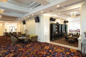 un vestíbulo con una zona de espera con sillas y mesas en Guilin Bravo Hotel, en Guilin